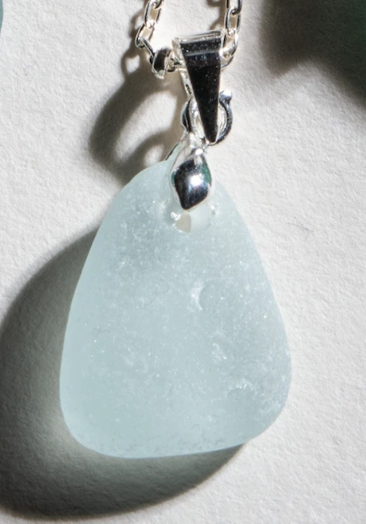 A petite piece of pale aqua sea glass suspended on an 18 inch silver chain